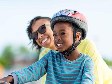 Mom helping son ride his bike