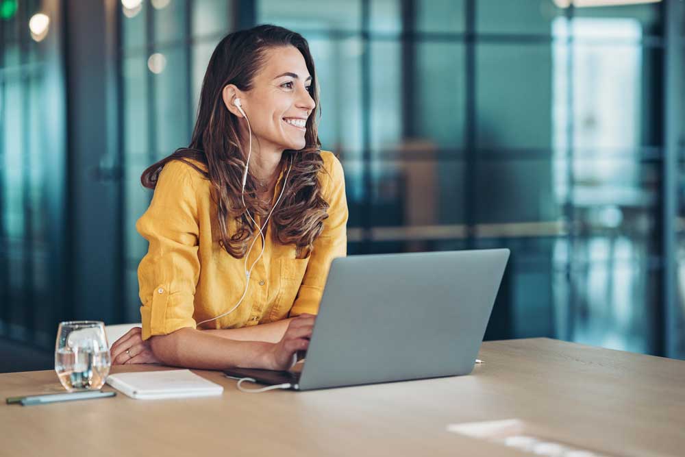woman at computer with headphones