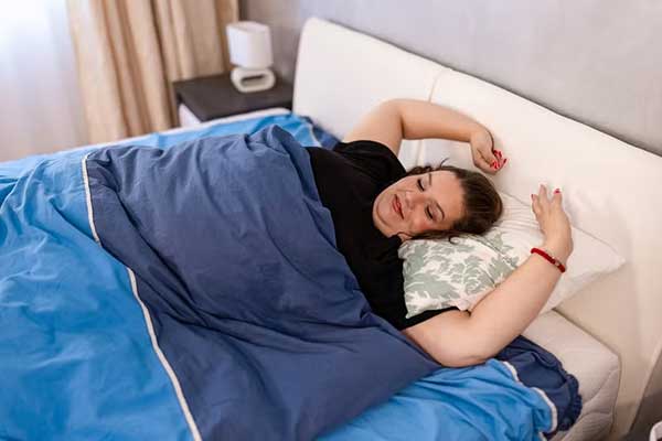 A woman wakes restfully in her bed from sleep