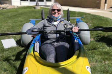 Sue sits in a kayak outside Inpatient Rehabilitation at Chelsea Hospital