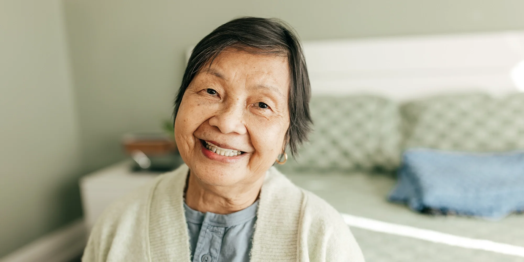 An aged woman smiles at the camera