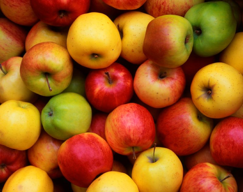 a pile of green, red and yellow apples