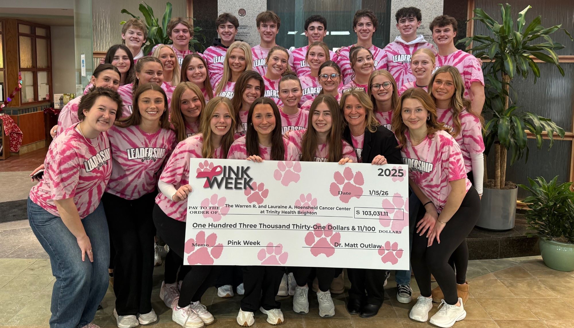 Brighton students gather around oversized donation check