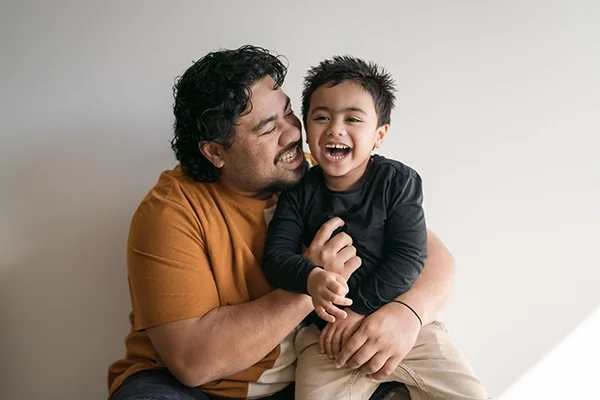A father and son cuddle and laugh