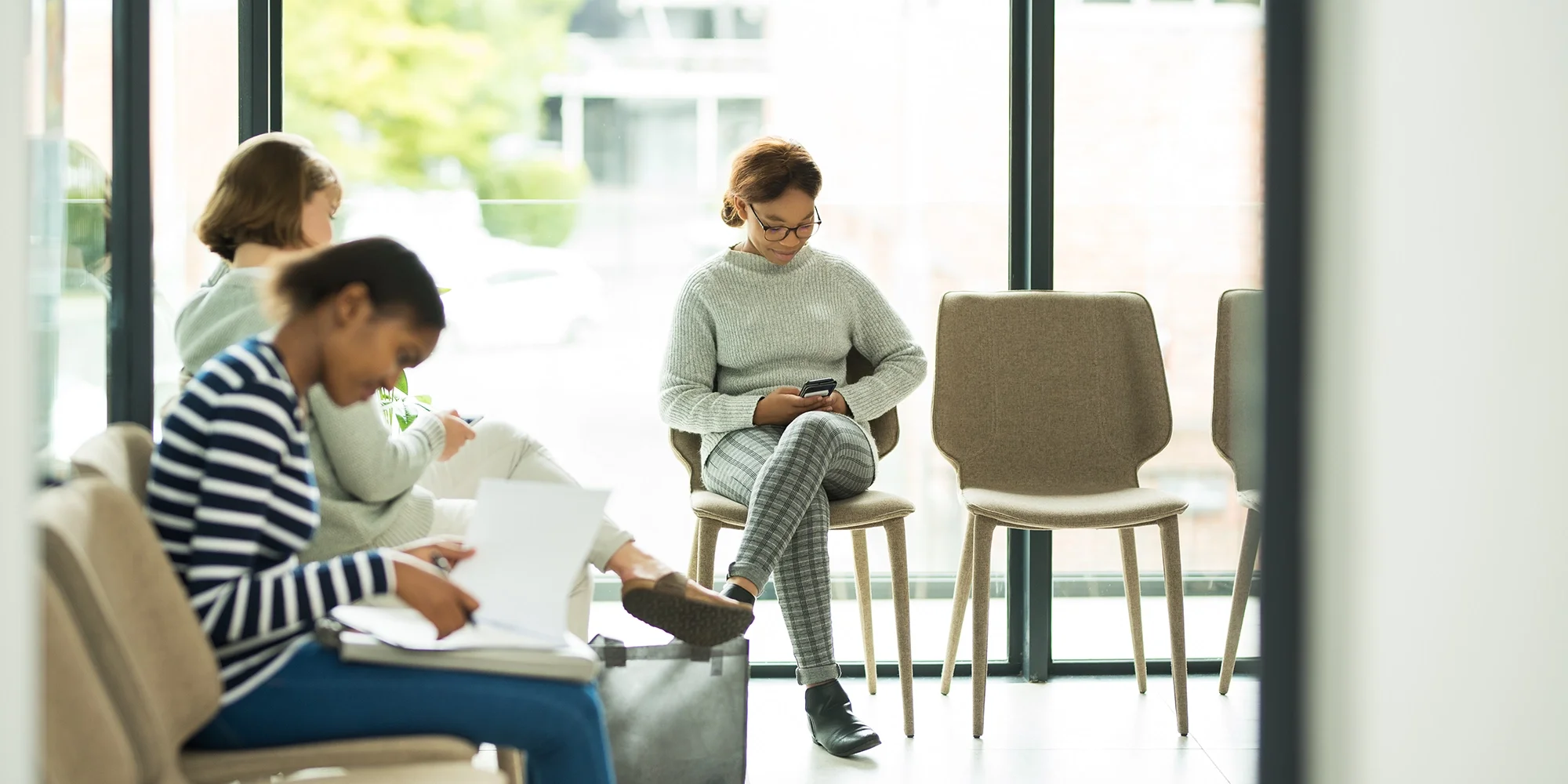 Three women wait in a hospital waiting room