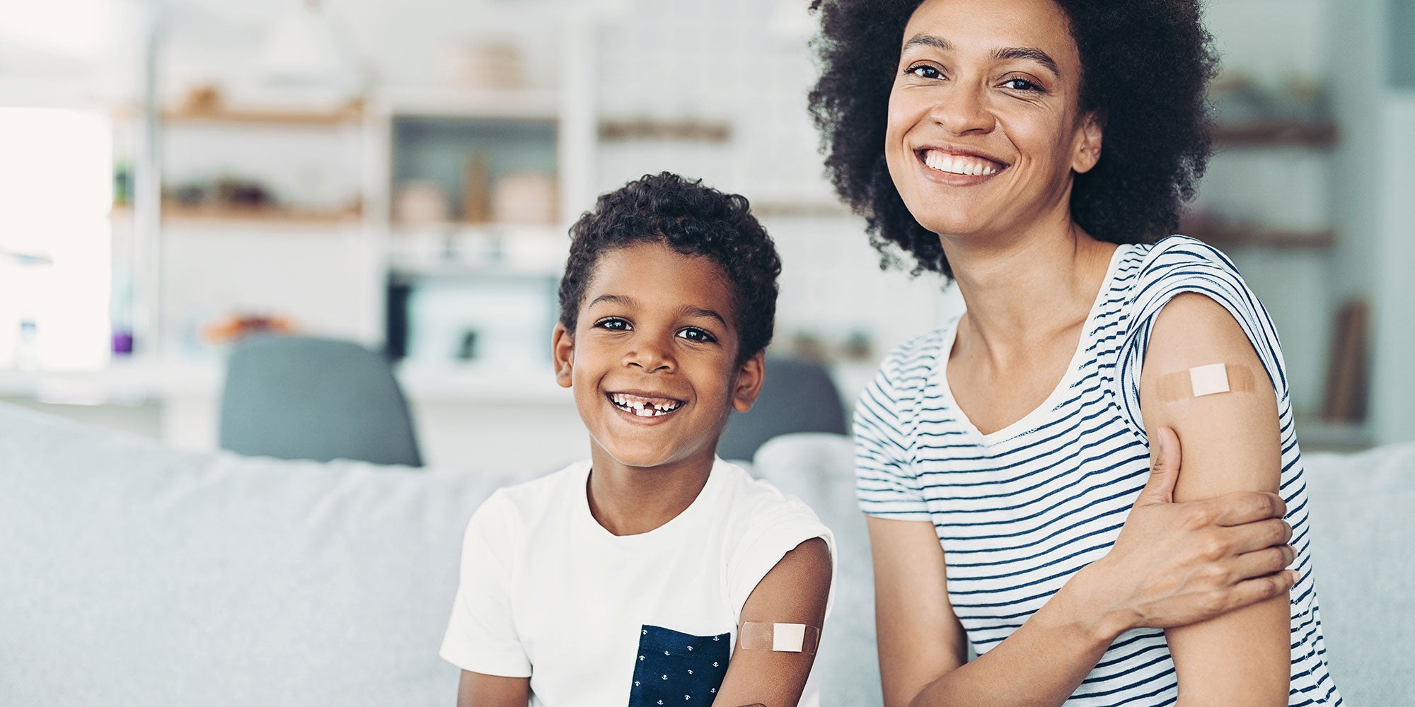 mother and son with bandaids on arm after flu shot