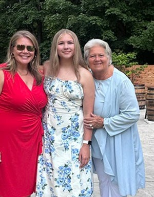 Fran, a former inpatient rehabilitation patient at Trinity Health Ann Arbor, smiles alongside her daughter and granddaughter.