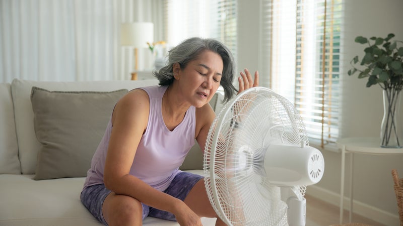 Woman sitting in front of fan
