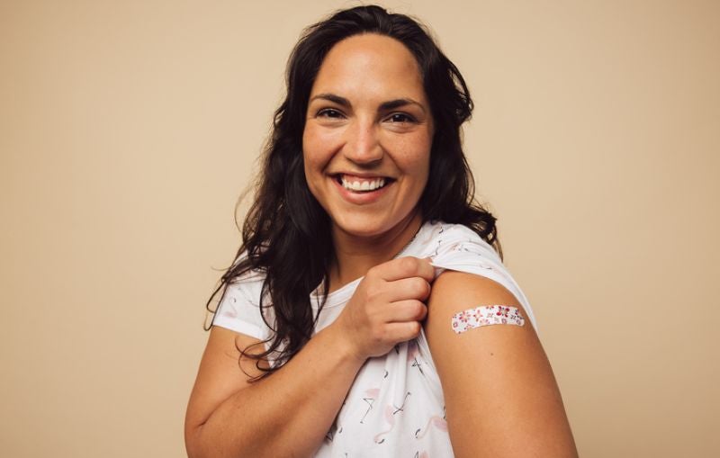 woman with bandage on arm after vaccine