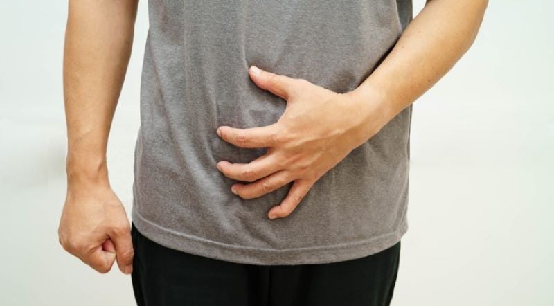man holding abdomen due to hernia pain