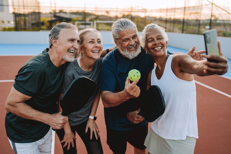 group of women and men playing pickleball