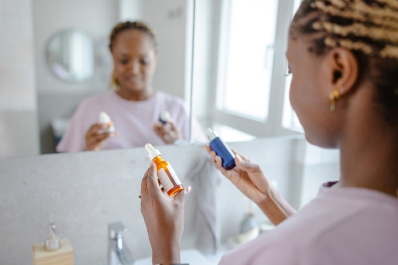 Woman looking at two skincare products