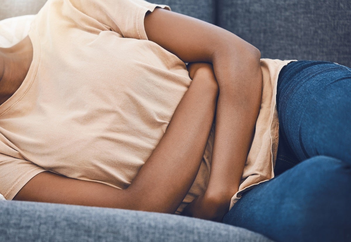 Woman lying on her side grasping her abdomen
