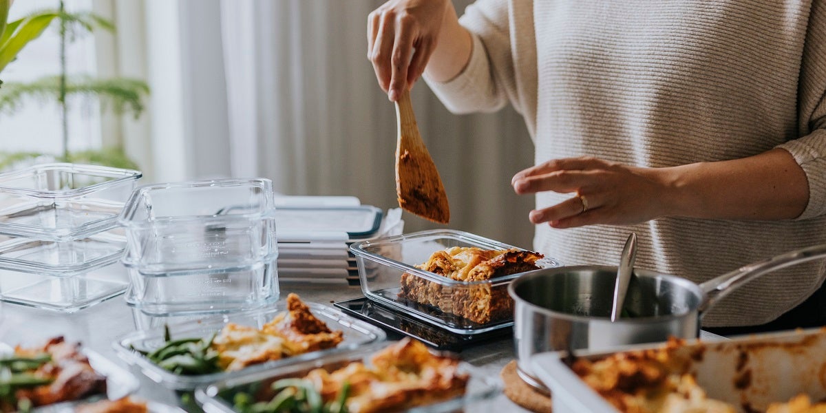 A person prepping meals ahead of time in their kitchen using glass containers.