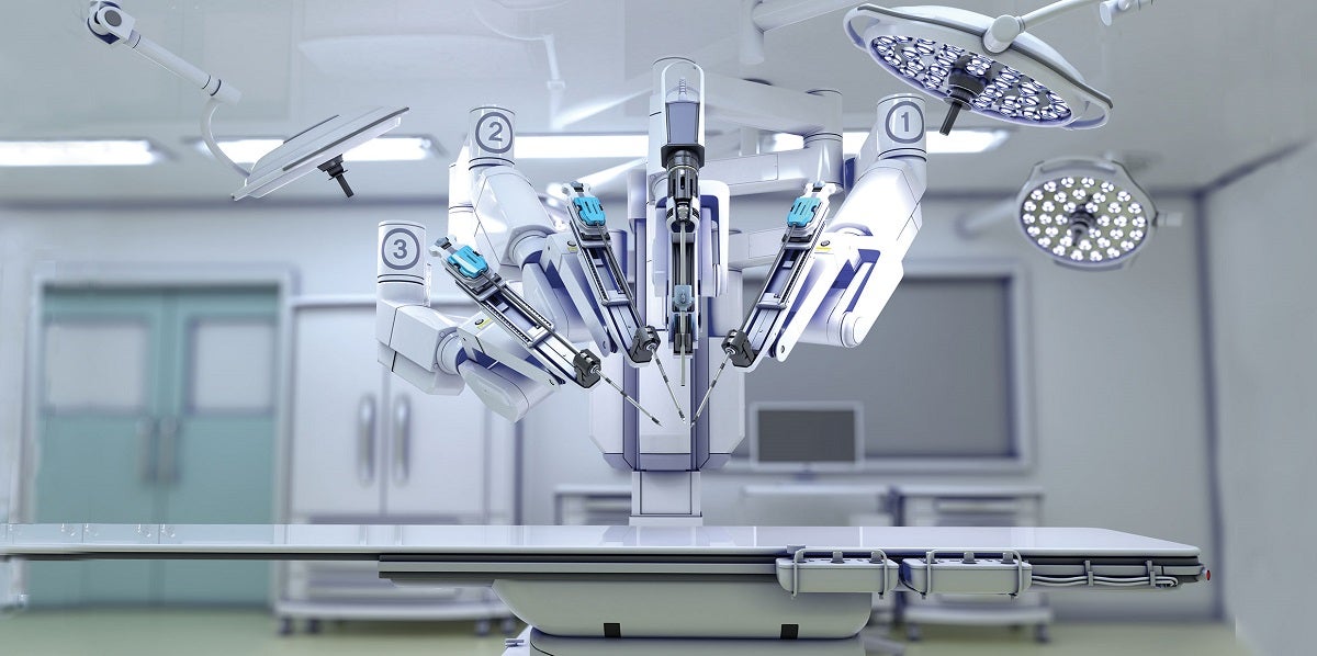 Digitally rendered image of the da Vinci robot shown in foreground with four ceiling lights in a white operating room.