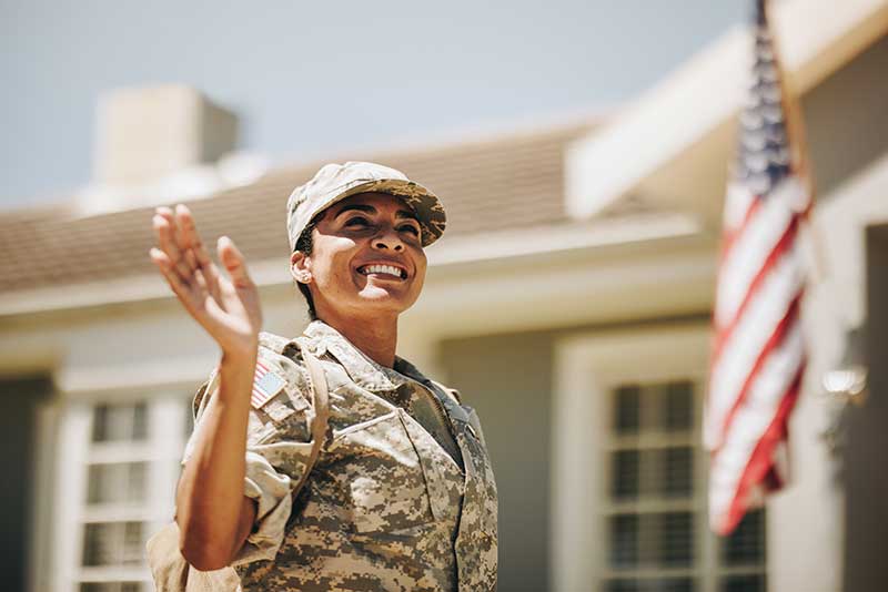 A veteran woman waves to people at her homecoming celebration