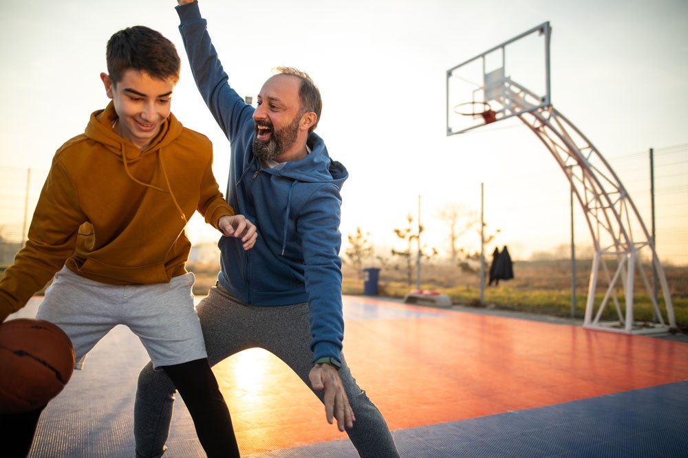 dad and son playing basketball