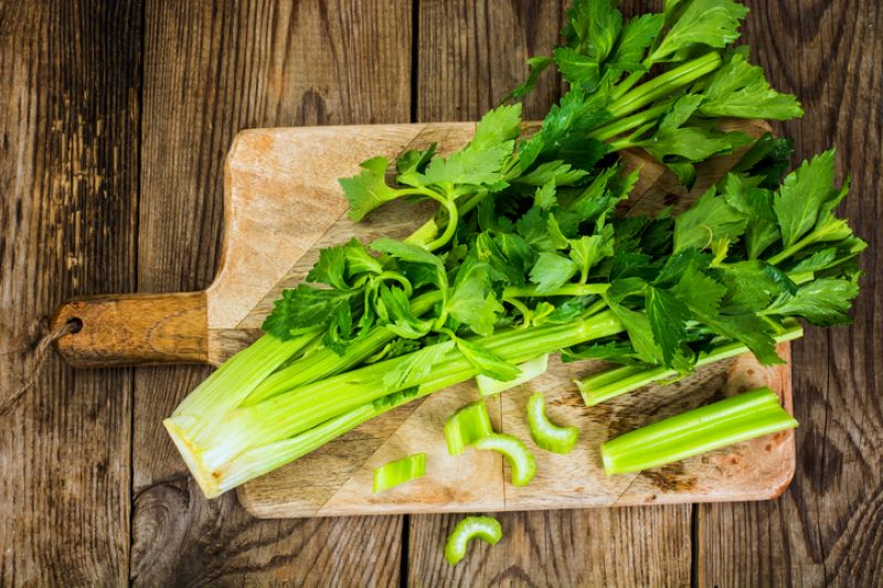Fresh celery on wooden cutting board